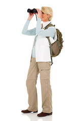 female hiker looking through binoculars