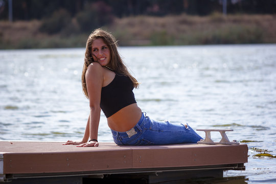 Adolescente de 15 a&ntilde;os en el embarcadero. Chica rubia adolescente pasando una tarde de verano junto al rio.