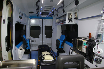 Interior of a modern ambulance with stretcher,heart monitor,defibrillator,oxygen,lights,night lights, seats for three paramedics