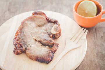 Pork steak on wooden plate