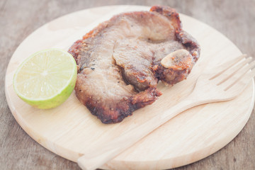 Pork steak on wooden plate