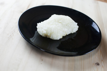 Sticky rice in the wooden bowl on wooden background