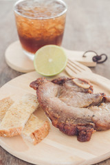 Pork steak on wooden plate