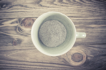 hot coffee cup on wood table Focus on coffee powder