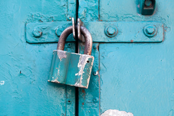 Retro metal lock on a emerald, cyan paint color door