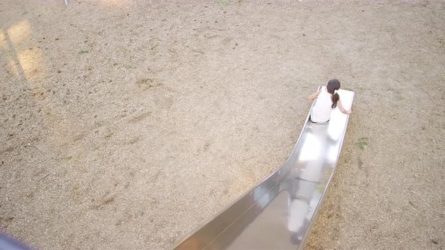 Young girls going down a slide at a park