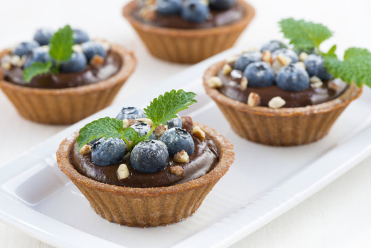 chocolate mousse with blueberries and mint in tartlets