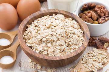 oat flakes and ingredients for making cookies on white table
