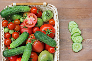 Fresh cucumbers, red and green tomatoes  in a basket