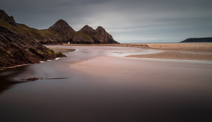 Fototapeta na wymiar The river at Three Cliffs Bay Well known landmark and beautiful beach in Gower, south Wales.