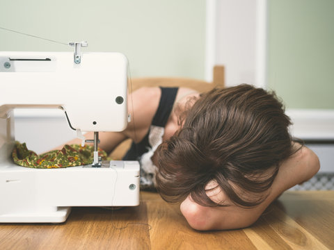 Tired woman by sewing machine