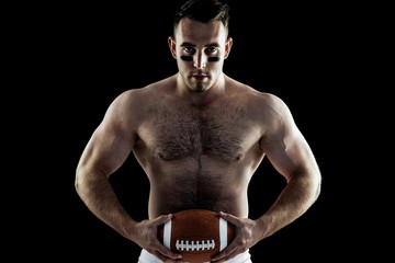Shirtless American football player with ball © WavebreakMediaMicro