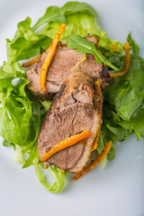 Roasted duck breast in orange on lettuce