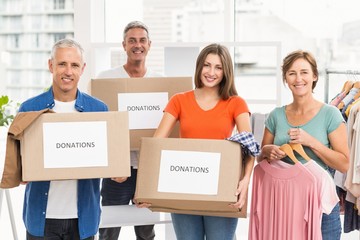 Smiling casual business people with donation boxes