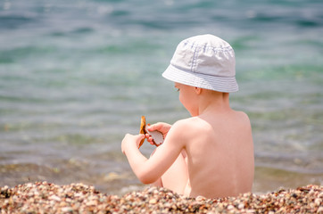 Little boy play near sea