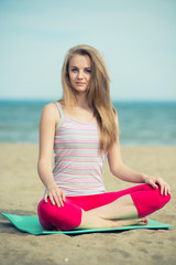 Fototapeta na wymiar Young lady practicing yoga. Workout near ocean sea coast.