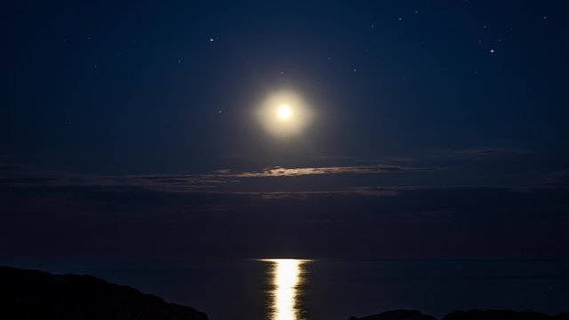 Timelapse moon in the starry sky in the night on sea