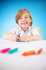 Composite image of cute boy colouring