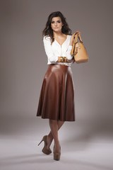 Elegant woman holding a brown purse.