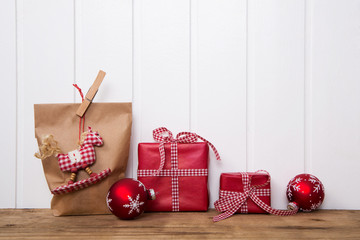 Geschenke weihnachtlich verpacken in rot weiß kariert mit Schleife als Dekoration auf Holz...