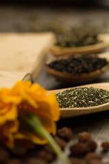 tea collection, flowers, old blank open book on wooden background. Menu, recipe, mock up