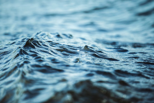 Closeup image of water waves outdoors at sea background.