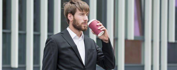 Handsome young boss drinking coffee