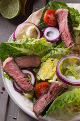 Mexican tortillas with green fresh salad filling, beef, onions, tomatoes with gucamole and tortilla chips on te vintage board