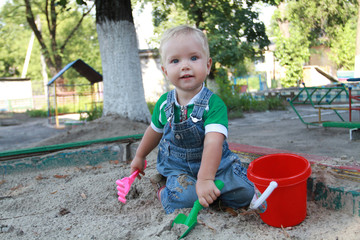 Маленький мальчик европейской (славянской) внешности играет в песочнице. Мальчику 1,4 года.