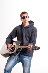 Image of teenager in black clothes, hoodie and sunglasses who is