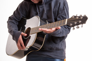 Close up of hands learning to playing an acoustic guitar