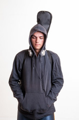 Fototapeta na wymiar Image of teenager in black clothes and hoodie with headphones is