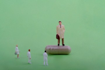 rappresentante farmaceutico in miniatura con medici e farmaco in capsula