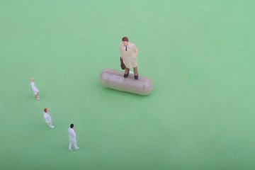 rappresentante farmaceutico in miniatura con medici e farmaco in capsula
