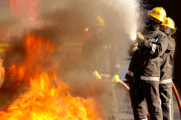 fire fighters fighting fire with hose real