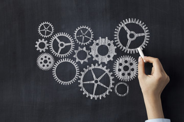 Cogwheels concept on blackboard © dragonstock