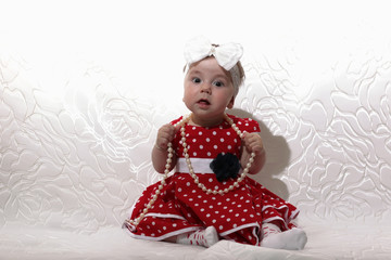 little girl in a red dress and beads