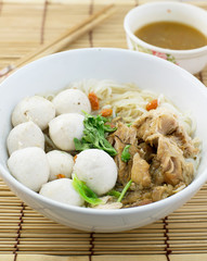 Pork balls and pork boiled noodle in a white bowl with chopsticks