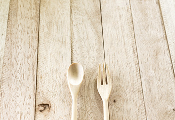 wooden spoon and wooden fork on wood table with vintage soft light