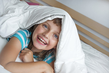 happy little girl resting in a bed