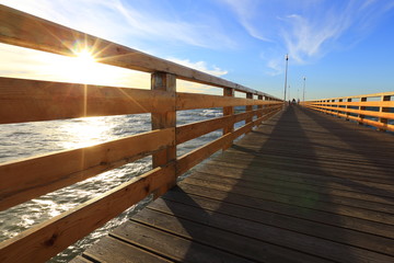 Wooden pier, long boardwalk and sea