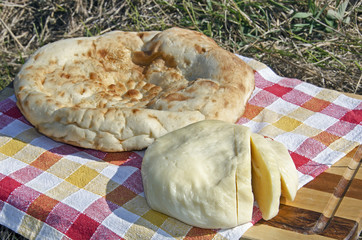 Outdoor picnic with homemade bread and cheese