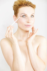 Obraz na płótnie Canvas Young woman applying make up