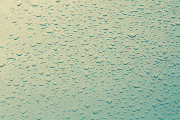Drop water rain on the green car in close up background and text