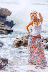 Beautiful young blonde woman posing outdoor at the rocky sea shore