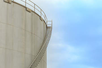 Staircase on big fuel tank on blue sky background