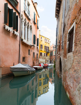 The reflection of a colorful houses in water canal, Venice, landmark of Veneto region, Italy