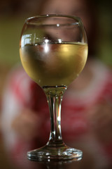 glass of white wine in a restaurant on a background of a person