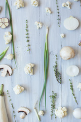 White and green vegetables on the blue wooden board top view.