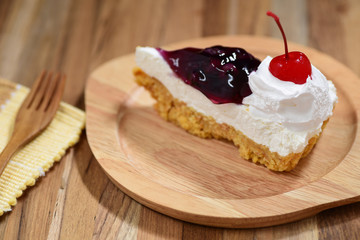 slice of blueberry cheese cake on wooden plate